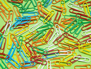 Colorful paper clip isolated on green background