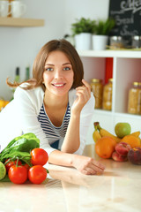 Young woman sitting near desk in the kitchen