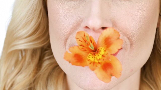 Girl with flowers between the lips