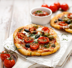 Vegetarian pizza with addition of tomatoes, olives and herbs