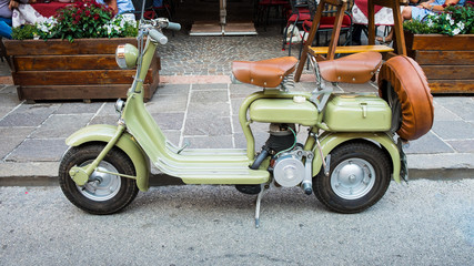 Scooter on foreground, vintage Italian scooter.