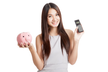 Beautiful young Asian woman with piggy bank and calculator