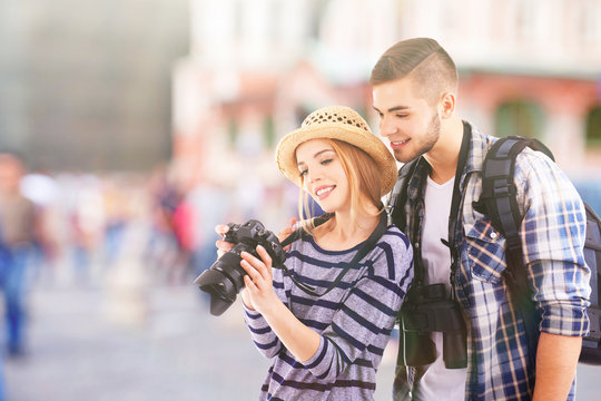 Young couple of travelers with camera on the street, outdoors