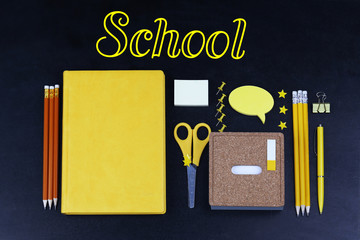 School supplies on blackboard background, close up