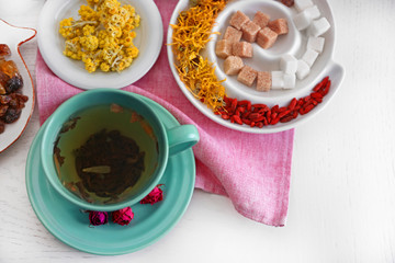 Cup of tea with aromatic dry tea on wooden background