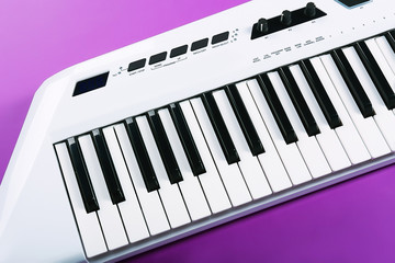 Fototapeta premium Keyboard of synthesizer on purple background