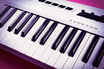 Keyboard of synthesizer on pink background