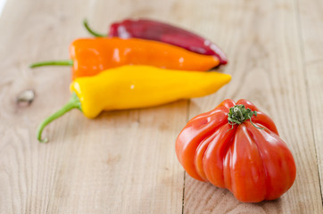 orange, yellow and red bell pepper and costoluto genovese tomato