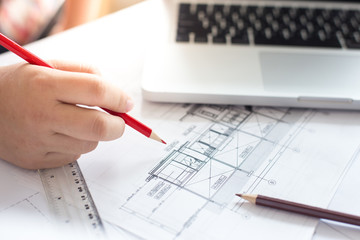 Creative architect projecting on the big drawings in the dark lo