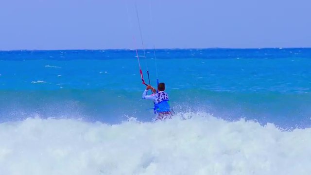 Beautiful moment of kite surfing athlete rides on edge of wave. Watersport video