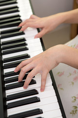 the woman  hands playing piano
