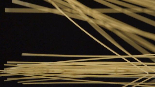 SLOW: A lot of a spaghetti fall on a black background

