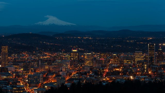 UHD 4k time lapse movie of auto traffic and light trails over snow covered Mt. Hood and city of Portland Oregon from daylight into blue hour 4096x2304