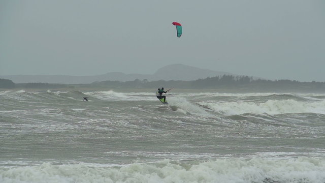 Kite surfers are surfing on large storm waves in North Wales as a stormy winter hits.