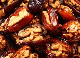 Walnut and date fruit on wooden table, close-up