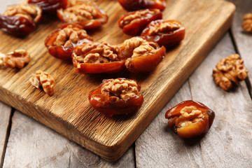 Walnut, date fruit on wooden table, close-up