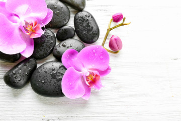 Obraz na płótnie Canvas Beautiful composition of orchid and pebbles on white wooden background, copy space