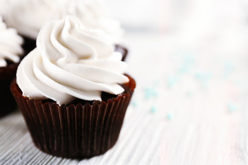 White cupcakes on wooden table