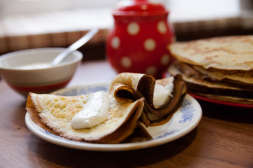delicious pancakes with sour cream on   white plate