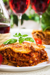 Piece of tasty hot lasagna with red wine..