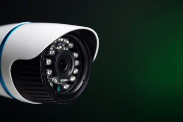 Security CCTV camera on green background, closeup