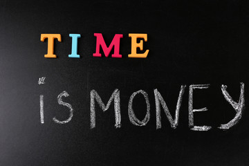 Time is money concept on a blackboard background