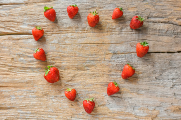 Strawberry lover.Fresh strawberry arranged in heart shape on vintage wood background