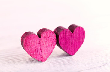 Fototapeta premium Two pink wooden hearts on white background love and romance concept valentine's day celebration relationship and affection