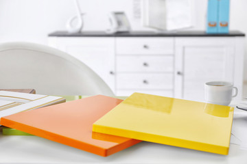 Samples of varicolored panels for furniture and door on white table