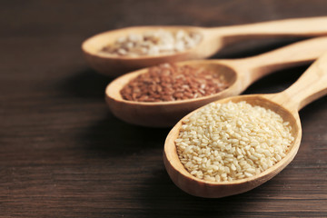 Sesame seeds in wooden spoons on table, closeup
