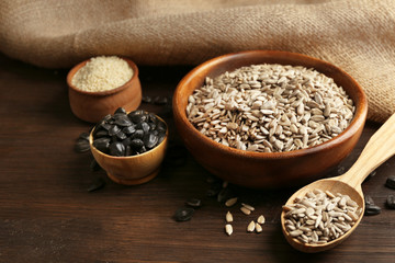 Peeled sunflower and sesame seeds on wooden table background, closeup