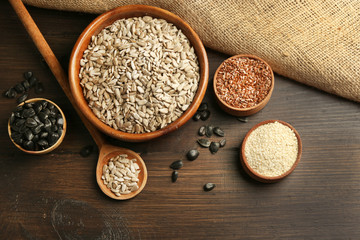 Peeled sunflower, flax and sesame seeds on wooden table background, closeup