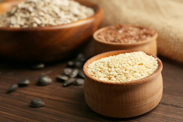 Sesame, flax and sunflower  seeds on wooden table background, closeup