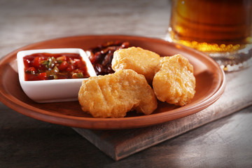 Snacks with glass mug of light beer on wooden table, closeup