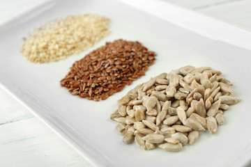 Sesame, flax and sunflower seed in plate on wooden table