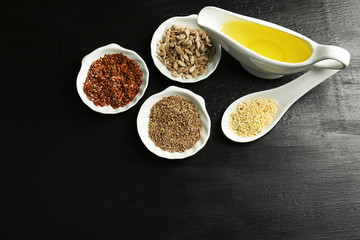 Different kinds of seeds and oil on wooden table