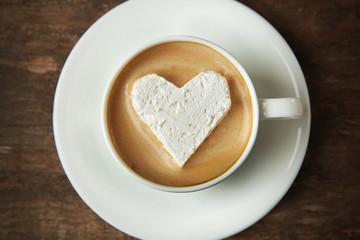 Cup of coffee with marshmallow on wooden table