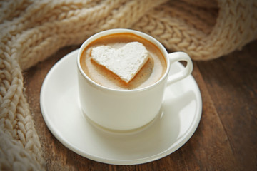 Cup of coffee with marshmallow on wooden table