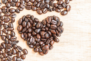 Coffee beans in heart shape  on wooden background
