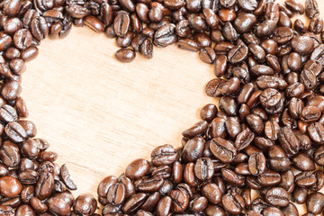 Coffee beans in heart shape  on wooden background