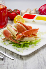 Boiled crab claws with sauce , lemon and cherry tomatoe with tasty drink over wooden background