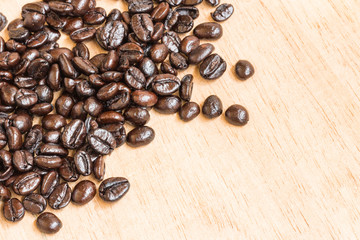 Brown roasted coffee beans on wooden background