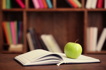 Apple and open book on the table, closeup