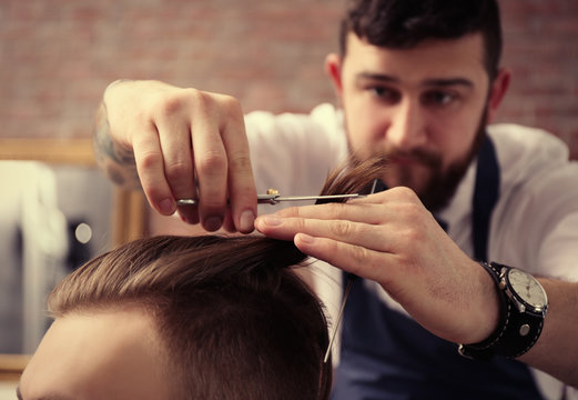 Professional barber making stylish man haircut