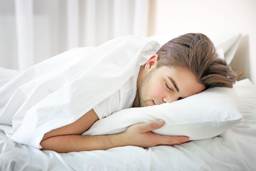 Fototapeta na wymiar Young man sleeping in bed at home