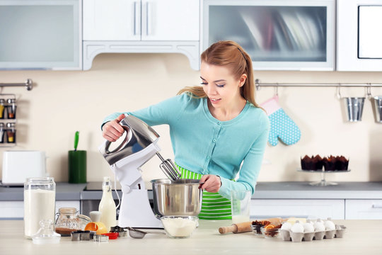 Young woman using a food processor to make a dough
