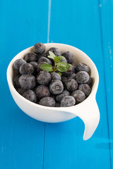 Heidelbeeren liegen in einer weißen Porzellanschale