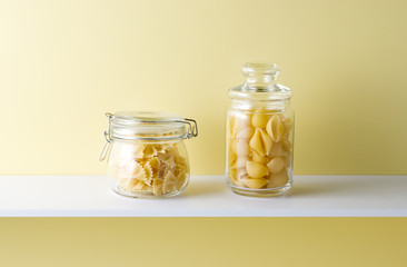 黄色い背景と棚とショートパスタ
