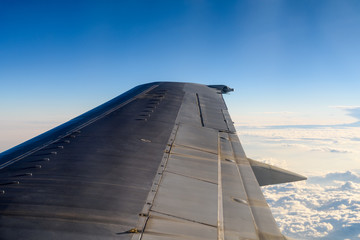 Window View Of Airplane Wing Flying Above Clouds