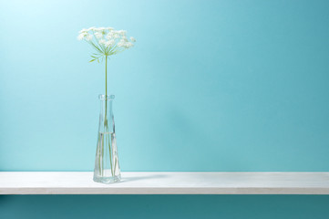 Obraz na płótnie Canvas 青い背景と棚と花瓶